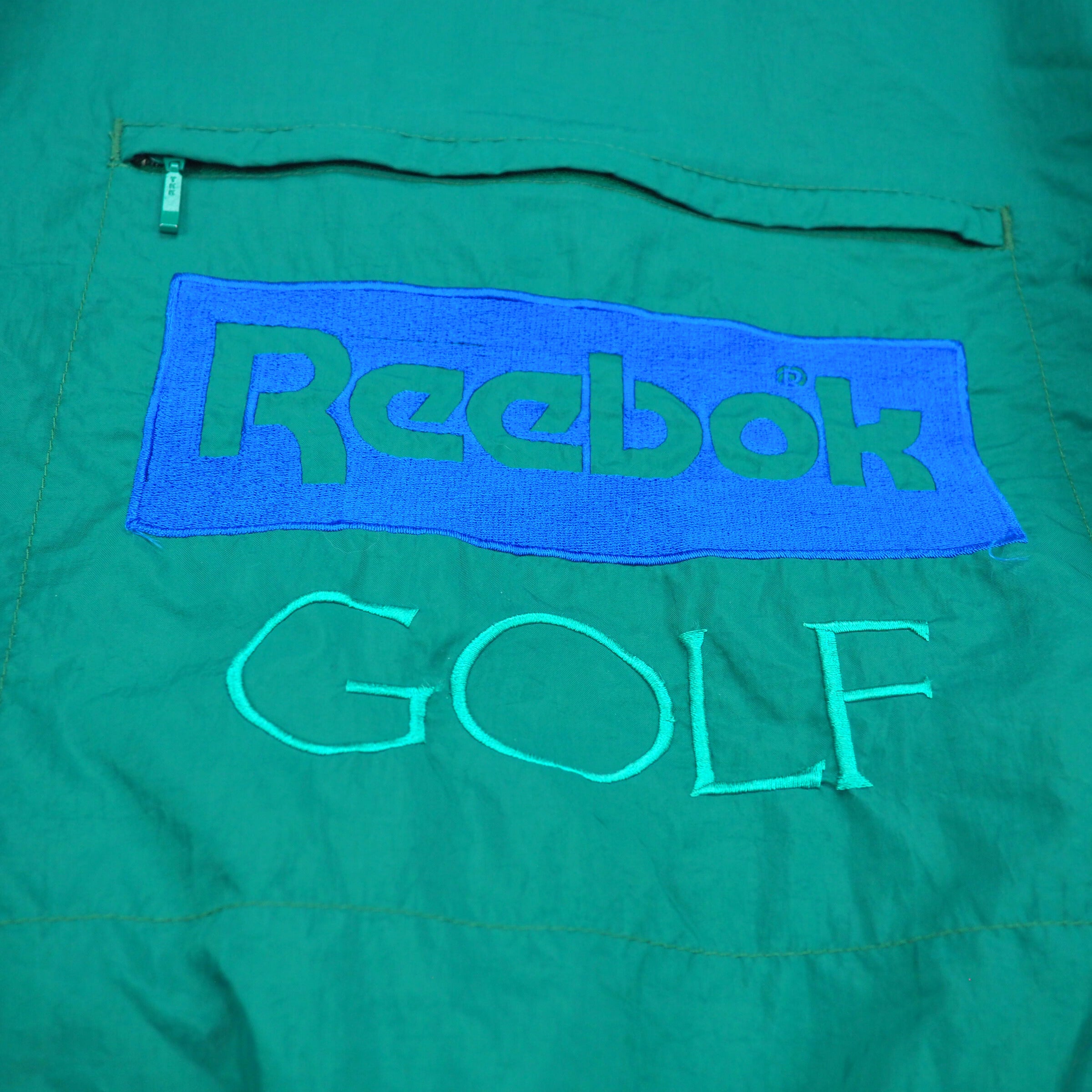 Green jacket with Reebok Golf logo on a green background