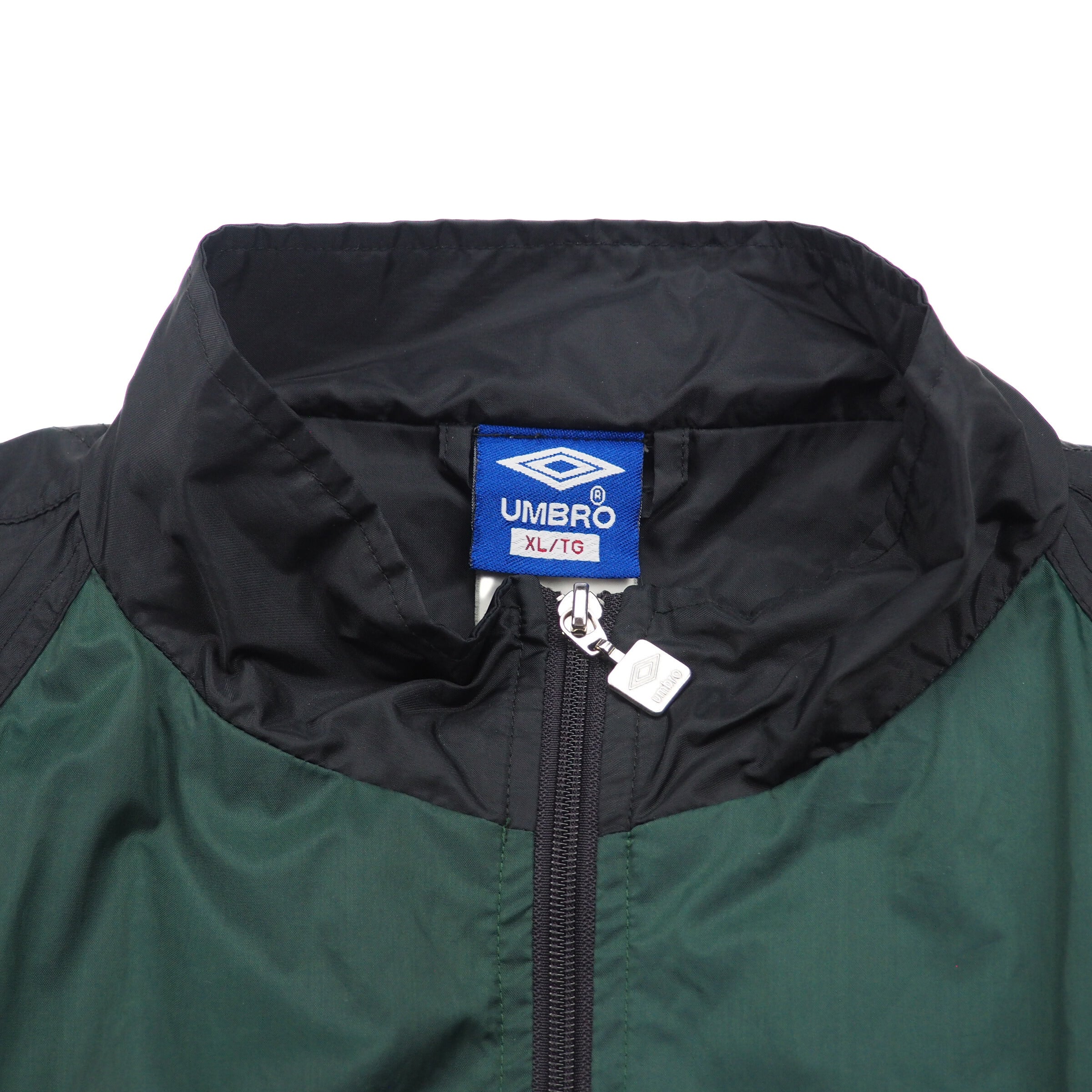 Close-up of a green jacket with a black hood and Umbro label.